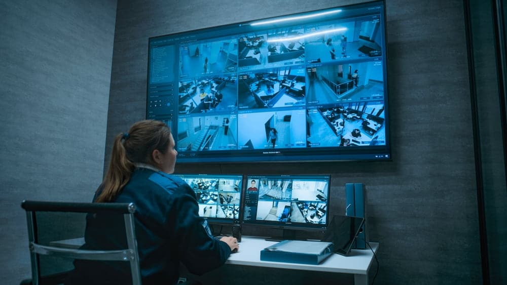 Security guard monitoring video surveillance screens in a security control center