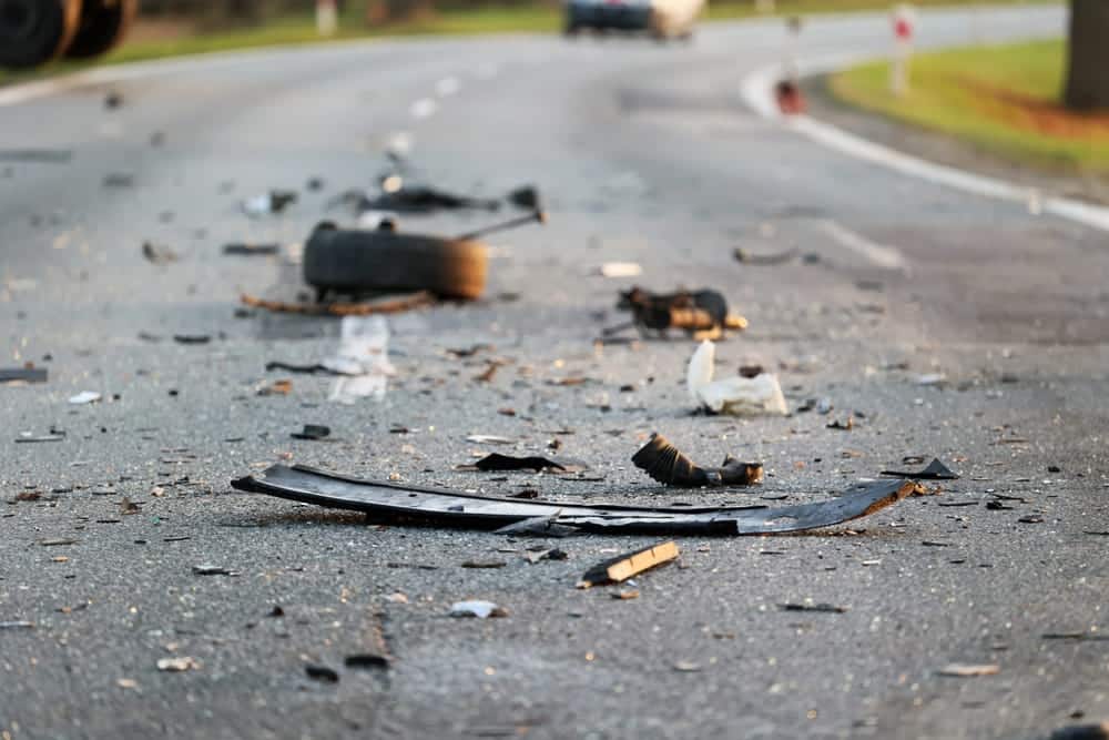 Pieces of debris scattered across a road after a vehicle accident