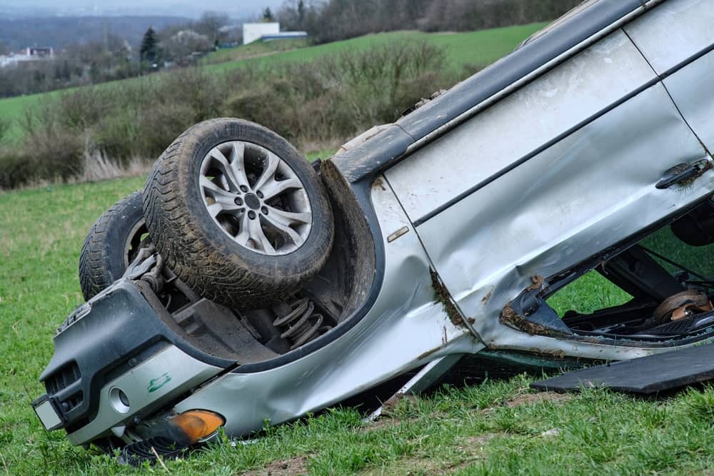 Overturned vehicle resting on its roof in a field after a rollover accident